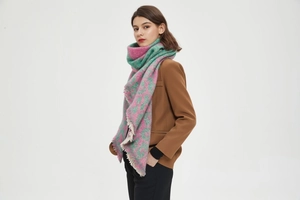 Detail of pink and green leopard print scarf with tassels on a soft textured knit