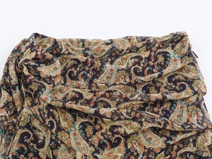 Détail du tissu doux montrant un motif paisley complexe et une texture tissée fine