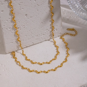 Macro detail of the gold crescent moon link chain showing the S.STEEL material stamp