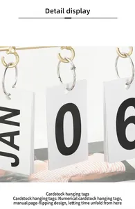 Close-up of manual flip calendar with white cards showing JAN 06 on golden metal stand