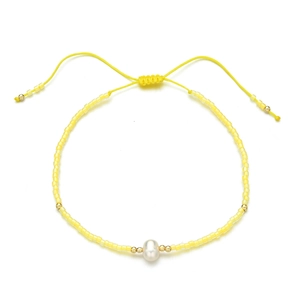 Detail of yellow bead bracelet with freshwater pearl and adjustable woven cord strap