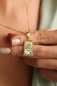 Detail of 18K gold tarot necklace featuring the Strength card with lion head design