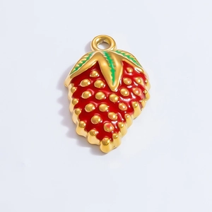 Macro detail of red strawberry pendant charm with gold plating and enamel finish