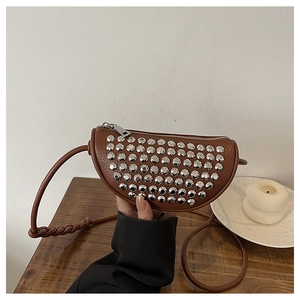 Detailed close-up of brown PU crossbody bag with silver studs and woven strap details