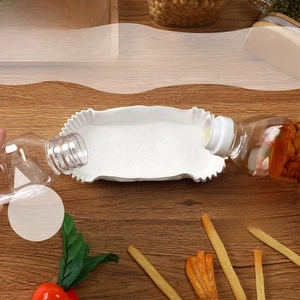 Waterproof and greaseproof white paper liners for air fryers shown on a wood table