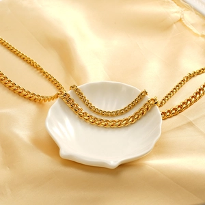 Collier gourmette plaqué or 18 carats en acier inoxydable sur une coupelle en céramique