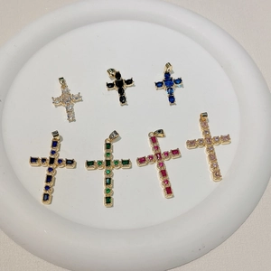 Set of seven gold plated cross pendants with colorful cubic zirconia on white display tray