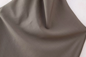 Vue macro détaillée de la texture du tissu tissé gris foncé et des détails de drapé
