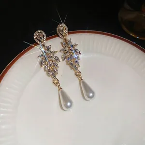 Elegant leaf-shaped crystal drop earrings with sparkling rhinestones and white pearls