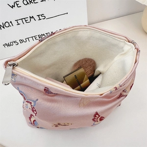 Close-up of pink jacquard shoulder bag with butterfly embroidery and cosmetic storage