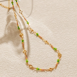 Detail shot of bohemian beaded necklace featuring clover charms and colorful stone beads