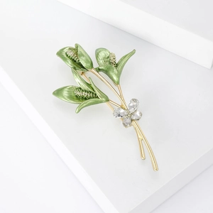 Macro shot of tulip brooch featuring green enamel leaves and sparkling crystal accents
