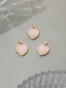 Detailed macro view of heart-shaped pink resin pendants with sparkling white zircon borders