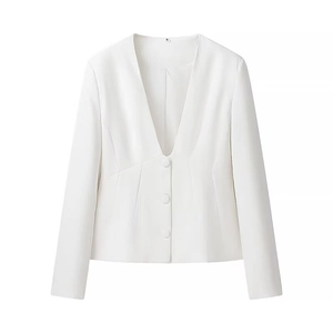 Detailed view of white deep V-neck blazer featuring a tailored waist and button detail