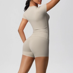 Rear view of women's beige tight yoga set featuring high-stretch shorts and slim-fit tee