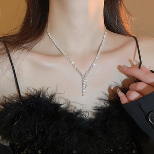 Elegant silver Y-shaped zircon tassel necklace worn by a model in black feather top