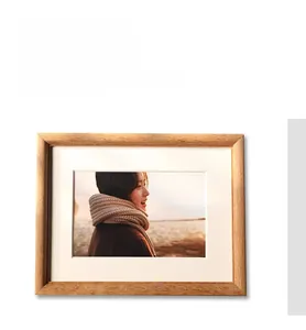 Detail of solid wood photo frame with natural wood grain texture and white mat insert