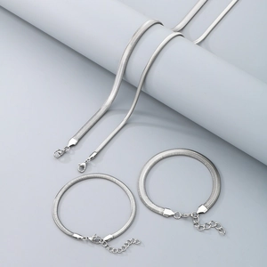Detailed view of silver flat snake chain necklaces and bracelets with lobster clasps