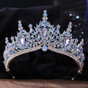 Detail of silver bridal crown with light blue crystals and rhinestones on black velvet