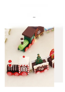 Close-up of painted wooden Christmas train with snowman and tree on white snow background