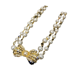 Double-layer pearl necklace with a vintage rhinestone bow pendant in golden finish