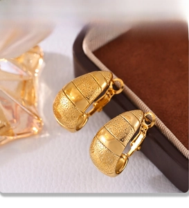Gros plan de boucles d'oreilles croissant plaquées or 18 carats avec finition PVD texturée