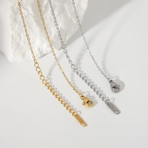 Detail of gold and silver lobster clasps and extension chains on white rock