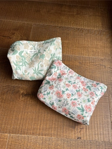 Flachbild von Vintage Baumwolltaschen mit Blumenmuster auf Holzboden zeigt Stofftextur