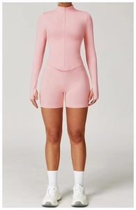 Détail de la veste de yoga rose cintrée avec col montant, zip et passe-pouces