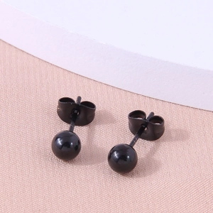 Minimalist 5mm black polished spherical stud earrings with butterfly backs on pink background