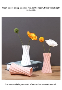 Detail of modern spiral texture vases in pink and white on a wooden tabletop