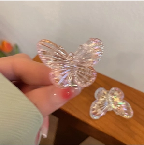 Macro detail of a colorful iridescent butterfly hair clip with a transparent resin finish