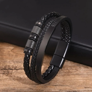 Bracelet pour homme en cuir tressé à trois couches avec fermoir magnétique sur fond de bois