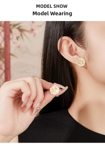 Detailed close-up of golden petal stud earrings with brushed texture and zircon stones