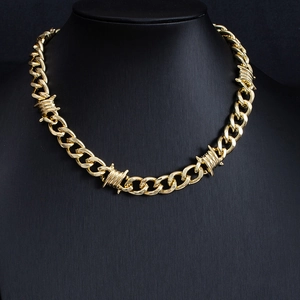 Detail of gold Cuban link chain with thorn wire design on a black mannequin bust