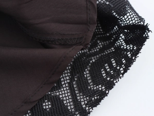 Détail macro du tissu marron foncé avec dentelle noire et coutures précises