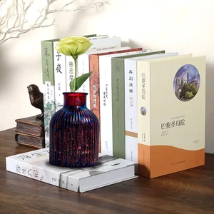 Close-up of ribbed dark purple glitter glass vase placed on books with a single flower