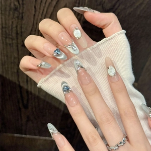 Handmade almond press-on nails with blue cat-eye effect, rhinestones and butterfly charms