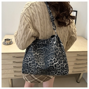 Detailed view of large leopard print tote bag featuring a knotted shoulder strap design