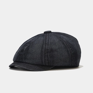 Close-up of retro denim newsboy cap featuring multi-panel stitching and top button detail