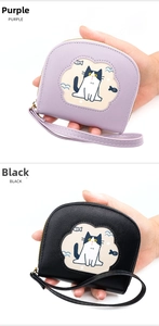 Detail of compact cartoon cat coin purses in purple and black with zipper and wrist strap