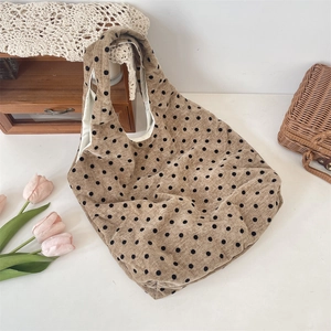 Detailed close-up of khaki canvas tote bag with black polka dots and soft fabric texture