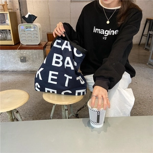 Close-up of a large capacity navy canvas tote bag with bold white letter print
