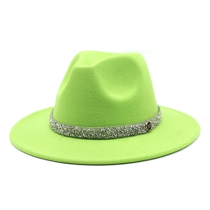 Detail of neon green wool fedora hat featuring rhinestone band and metal M ornament