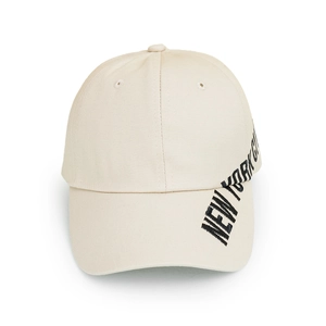 Detailed side view of beige cotton baseball cap featuring New York City black embroidery