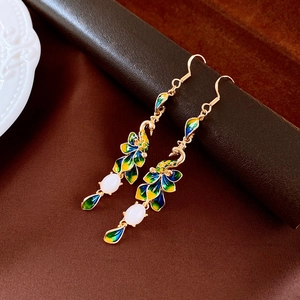 Detailed peacock earring with enamel feathers and white bead on brown leather
