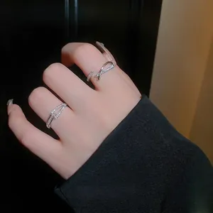 Bague croisée minimaliste en zircon argenté présentée sur la main avec contraste