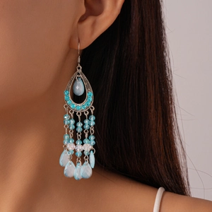 Detail view of Bohemian tassel earrings with blue crystals and silver droplet design