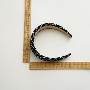 Detail of black and white tweed wide headband showing elegant woven fabric texture and size