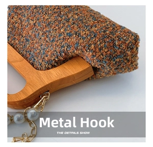 Detail of wooden handle and golden hardware hook on woven tweed bag with pearls